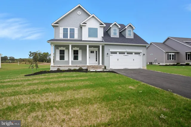 a front view of a house with a garden and yard