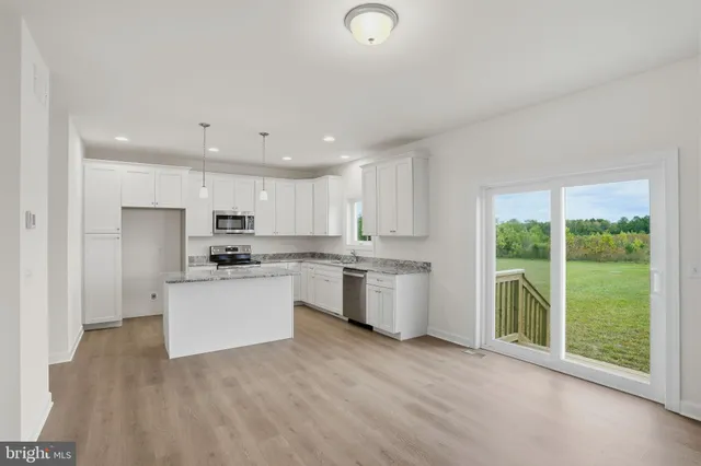 a kitchen with a refrigerator and white cabinets