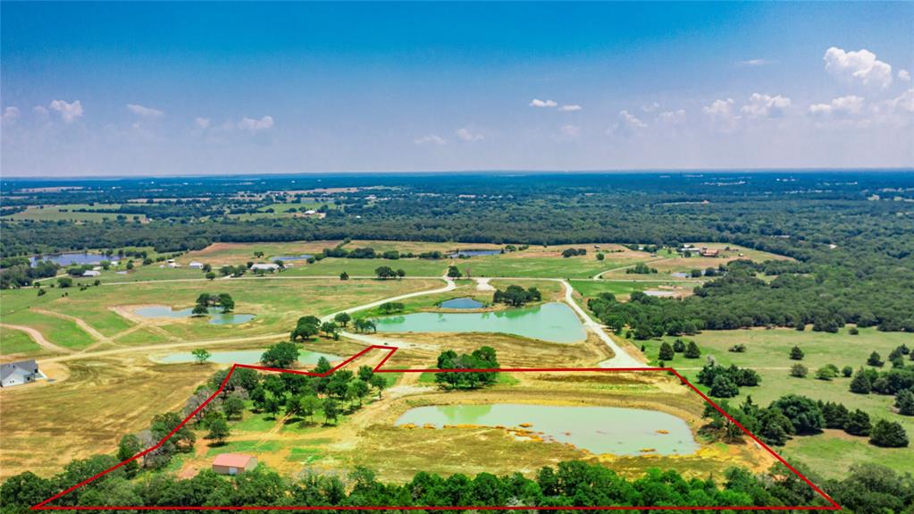1789 Brumelow Road Whitesboro, TX 76273 - Photo 22 of 30 Expansive land parcel featuring multiple ponds, a secluded building, and scattered trees