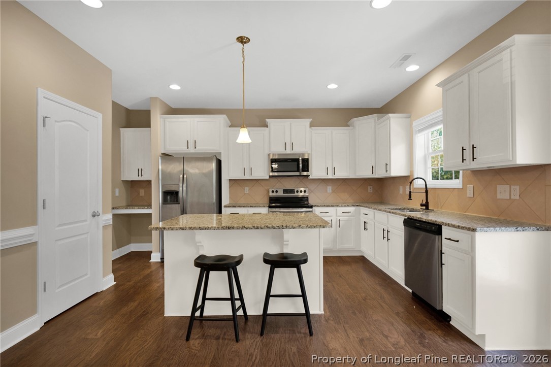 448 Pittfield Run Cameron, NC 28326 - Photo 13 of 43 a kitchen with stainless steel appliances granite countertop white cabinets a sink a stove a refrigerator and island