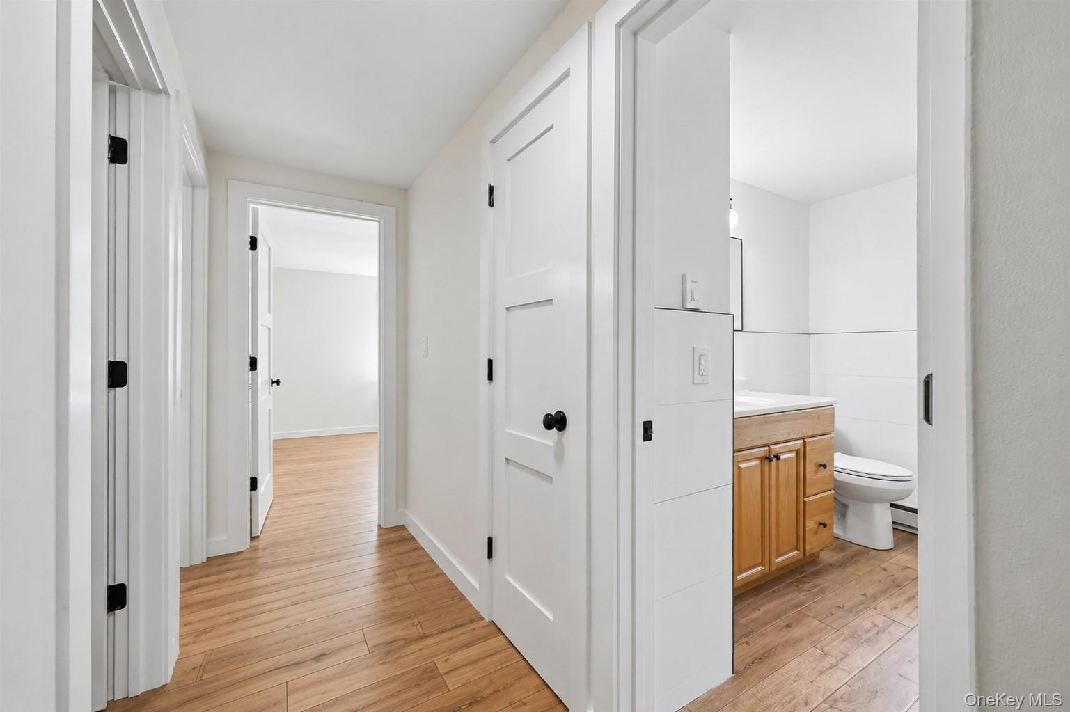 249 Ridge Road Highland Mills, NY 10930 - Photo 22 of 38 Hallway featuring wood-finish flooring, white walls, and white trim