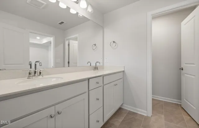 a bathroom with double sink and a mirror