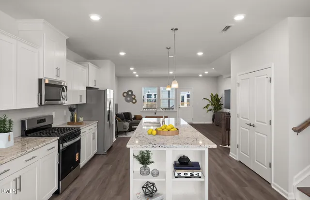 a kitchen with stainless steel appliances granite countertop a sink refrigerator and microwave