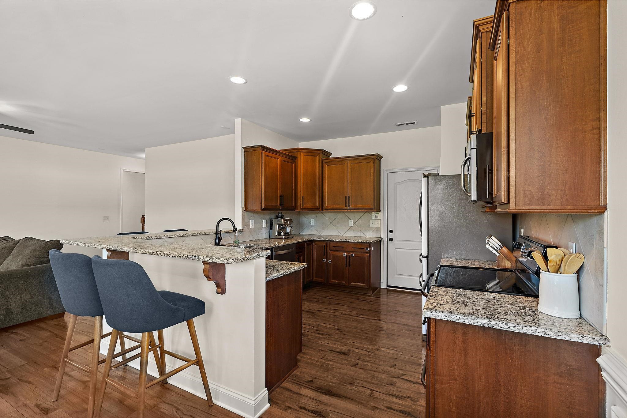 139 Torchie Drive Selma, NC 27576 - Photo 12 of 49 a kitchen with kitchen island granite countertop wooden cabinets a counter top space a sink and appliances