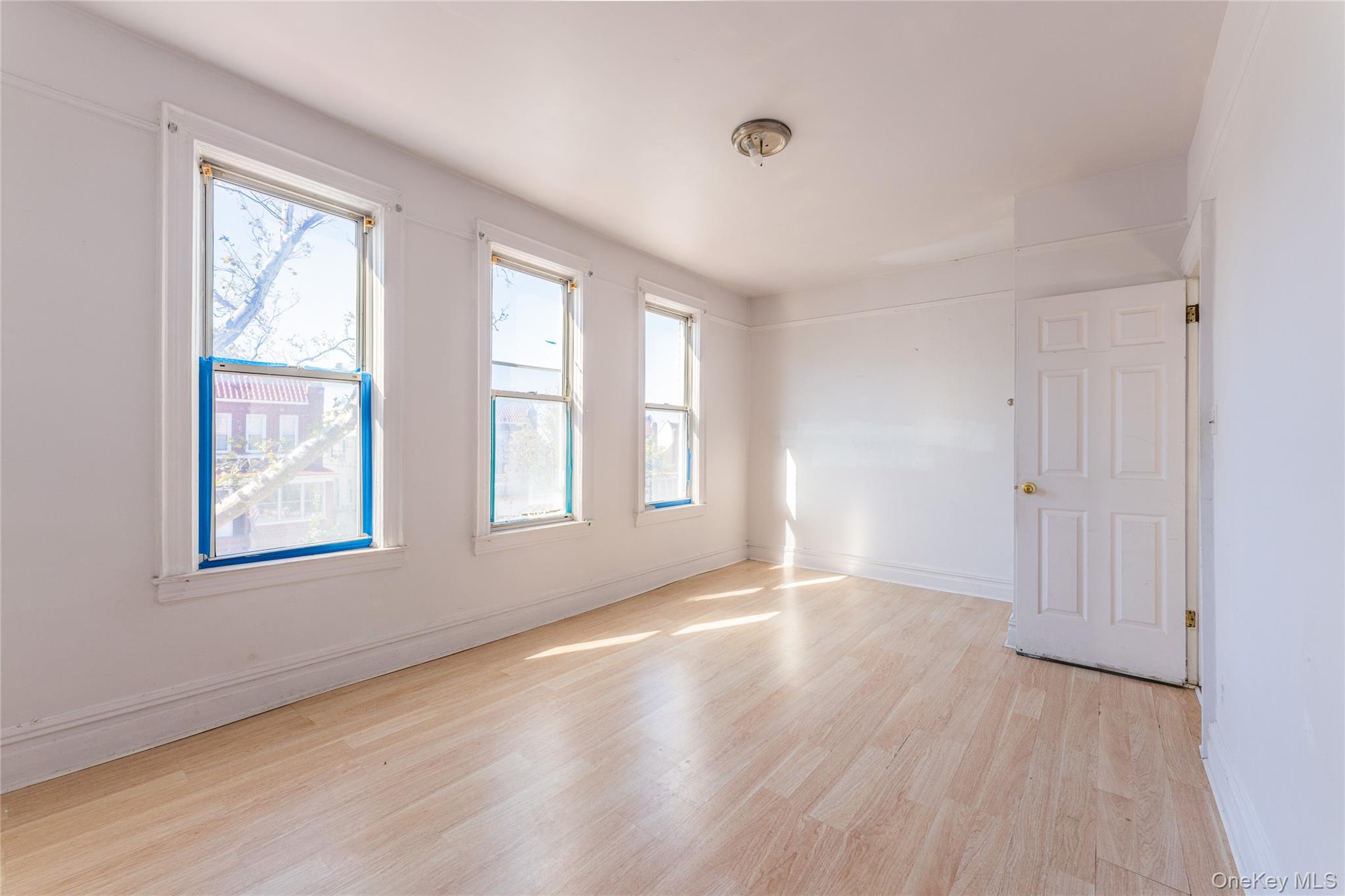 31-39 84th Street Queens, NY 11370 - Photo 17 of 29 a view of an empty room with wooden floor and a window