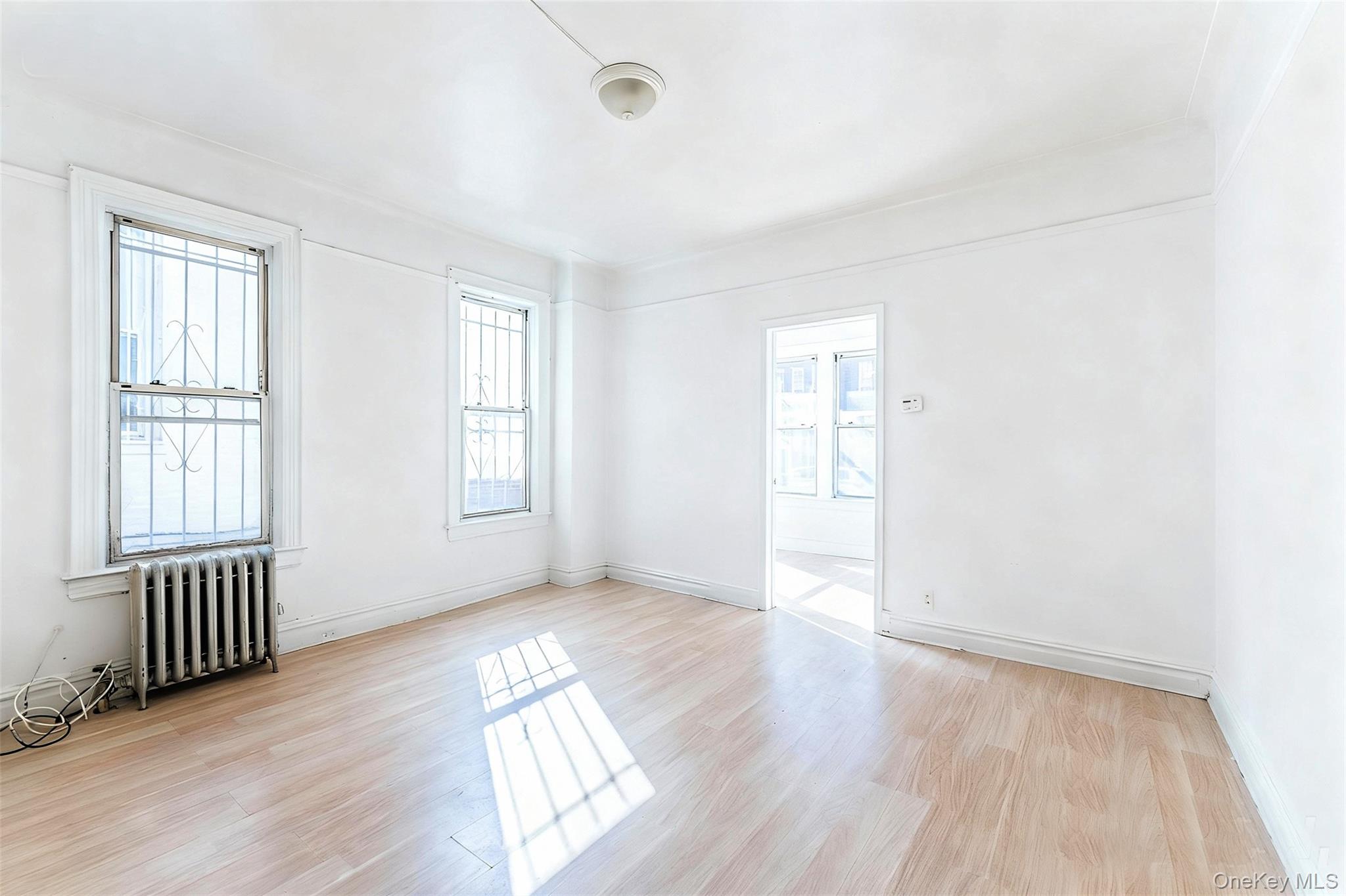 31-39 84th Street Queens, NY 11370 - Photo 20 of 29 an empty room with wooden floor and windows