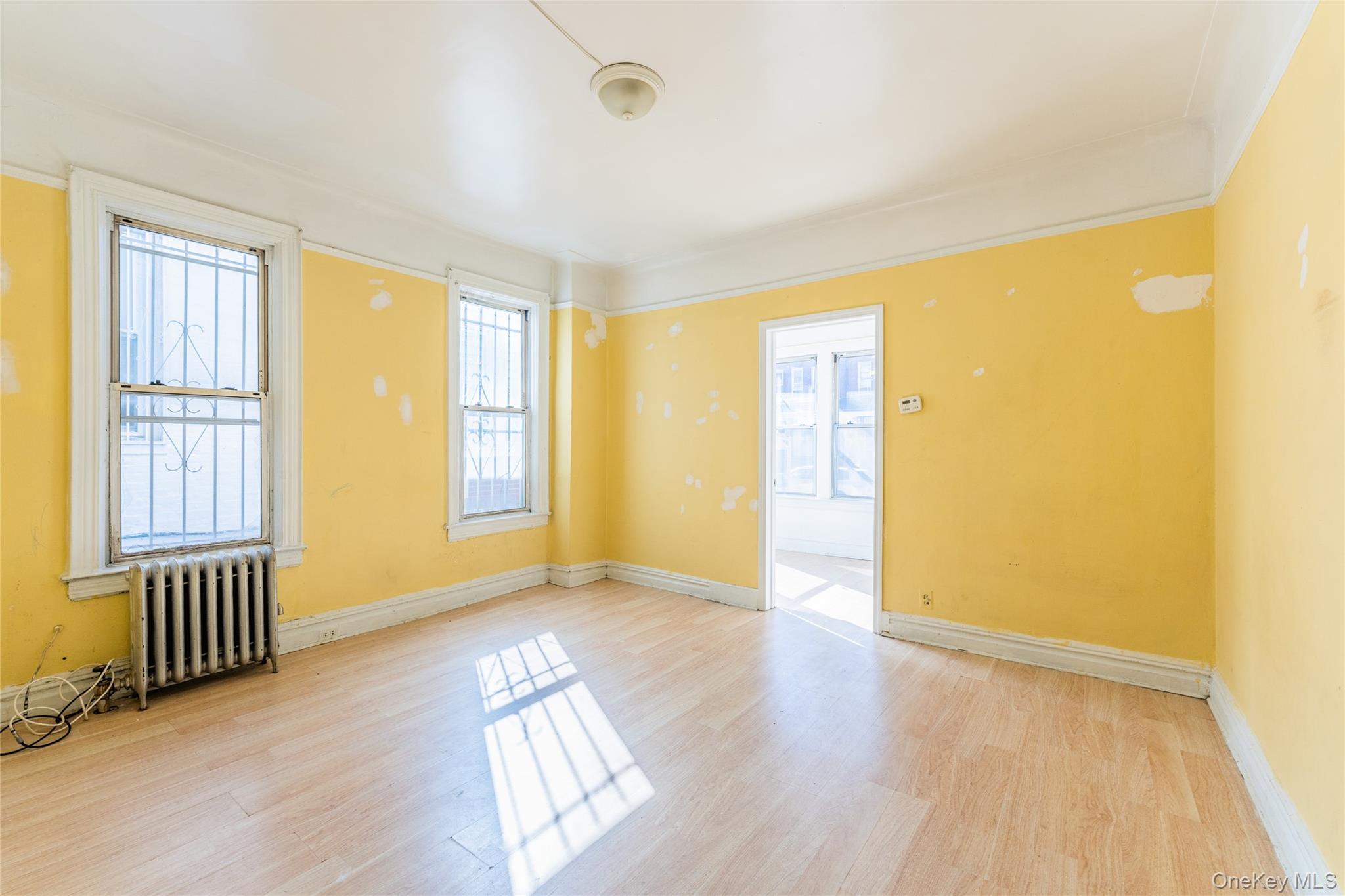 31-39 84th Street Queens, NY 11370 - Photo 10 of 29 a view of an empty room with a window and wooden floor