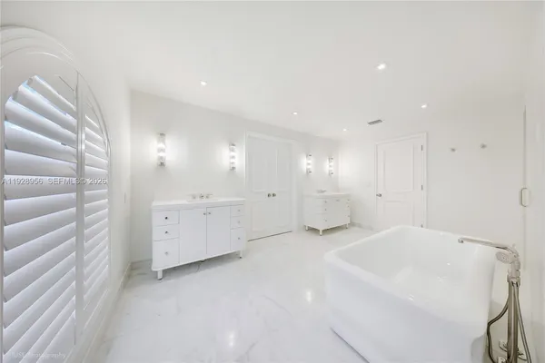 a spacious bedroom with a bed and a painting on the wall