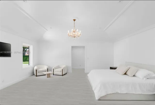 a bedroom with a bed and a chandelier