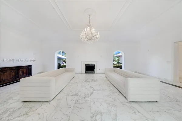 a spacious bedroom with a large bed and a chandelier