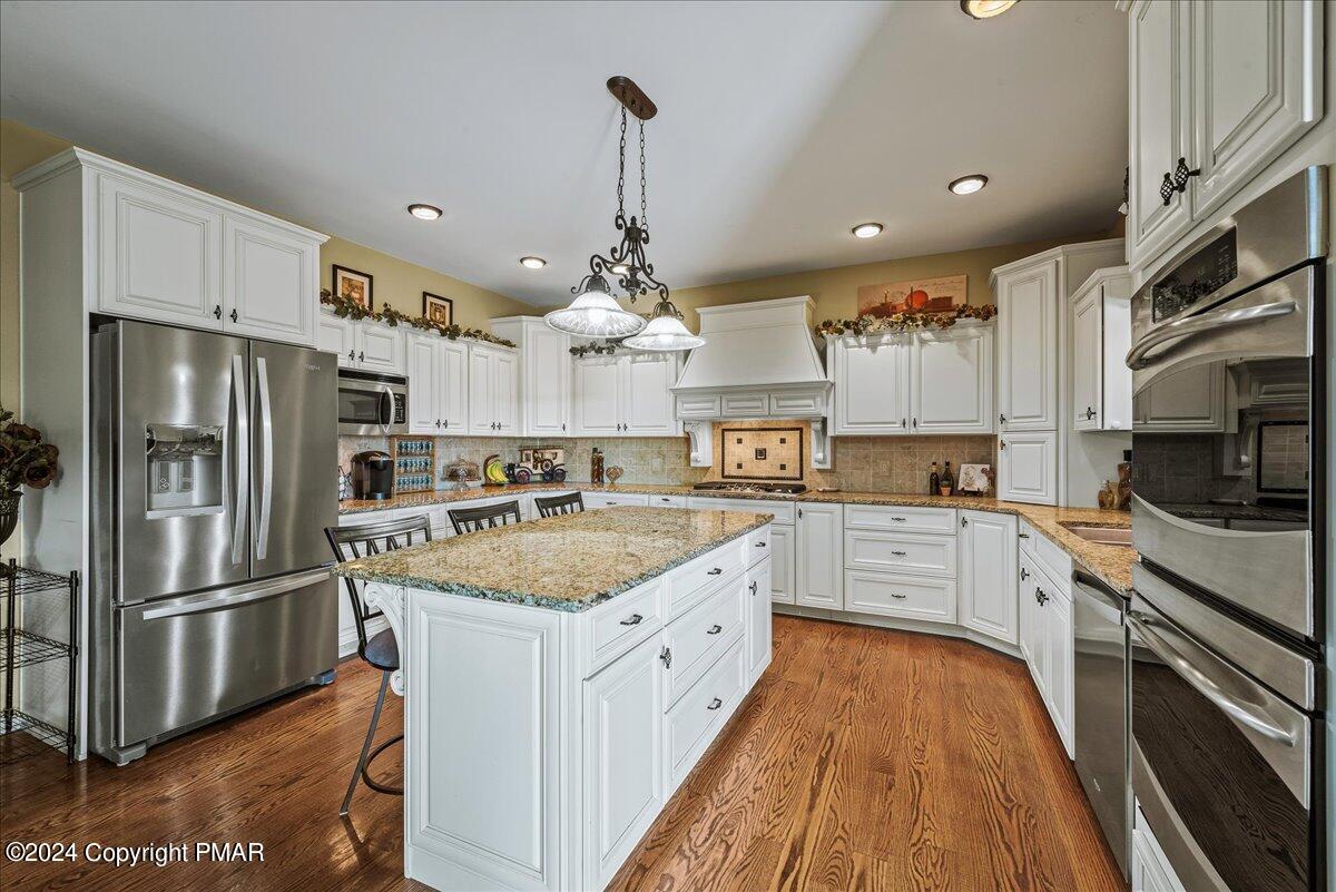 3209 Crest Vue Circle Danielsville, PA 18038 - Photo 29 of 95 a large kitchen with stainless steel appliances kitchen island granite countertop a refrigerator a stove a sink dishwasher and white cabinets with wooden floor