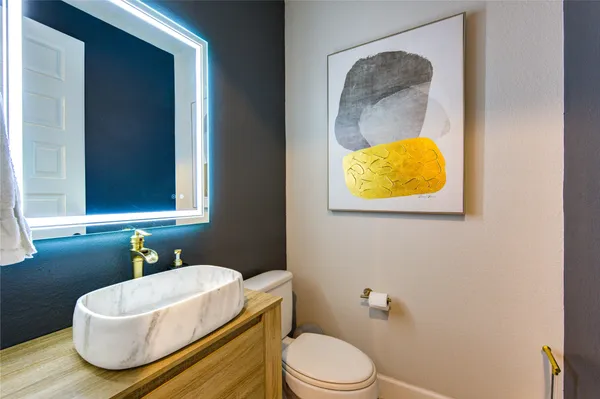 a bathroom with a sink vanity mirror and toilet