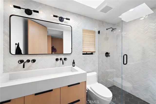 a bathroom with a toilet sink shower and mirror