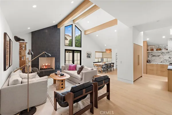 a living room with furniture a rug and kitchen view