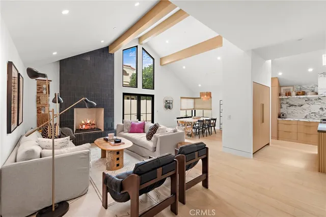 a living room with furniture a rug and kitchen view
