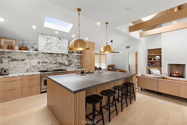 a kitchen with stainless steel appliances granite countertop a sink a stove and a wooden floors