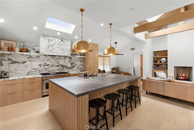 a kitchen with stainless steel appliances granite countertop a sink a stove and a wooden floors