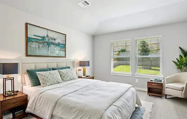 a bedroom with a bed couch and a large window