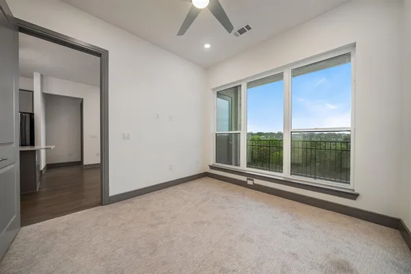 an empty room with floor to ceiling windows and an outdoor view
