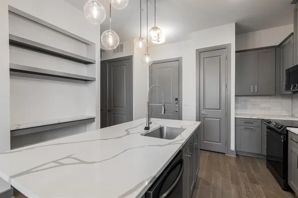 a kitchen with a sink and a large mirror