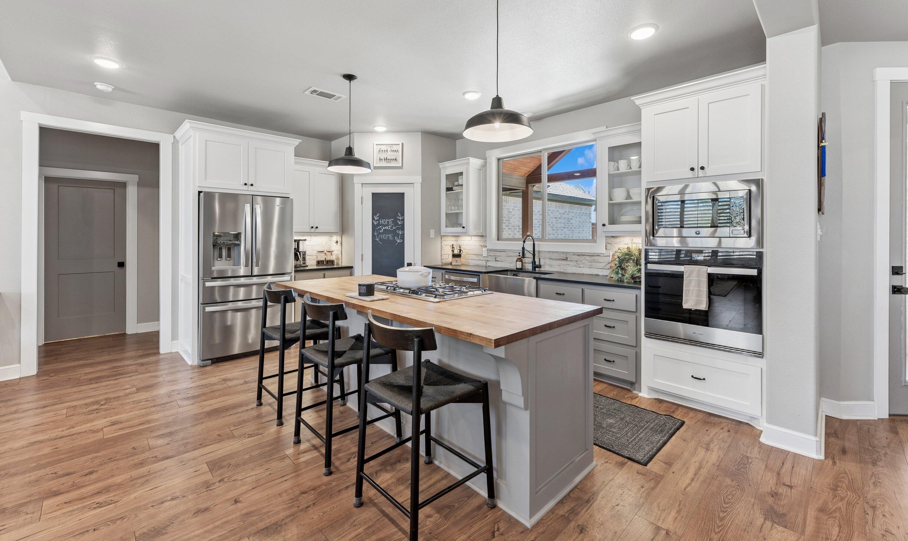 629 North 9th Street Wolfforth, TX 79382 - Photo 12 of 45 a kitchen with stainless steel appliances kitchen island granite countertop a table chairs and a refrigerator