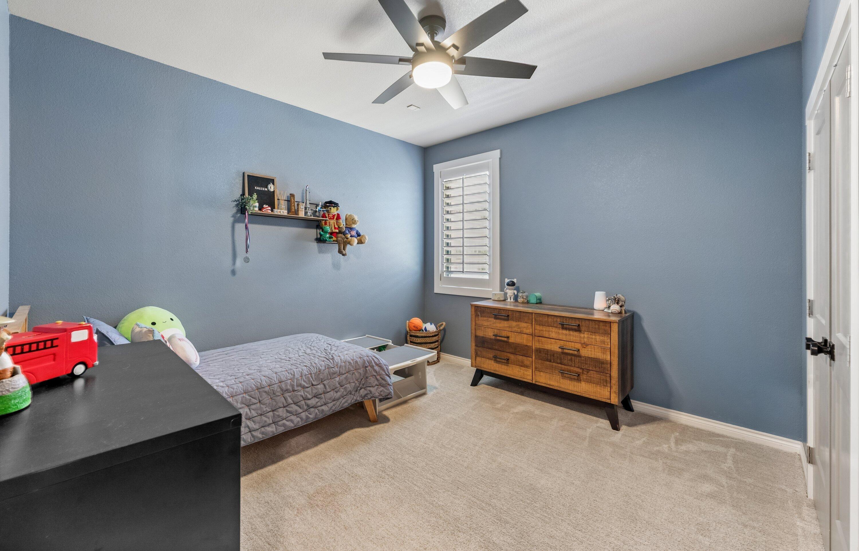 629 North 9th Street Wolfforth, TX 79382 - Photo 28 of 45 a bedroom with a bed and a chandelier fan