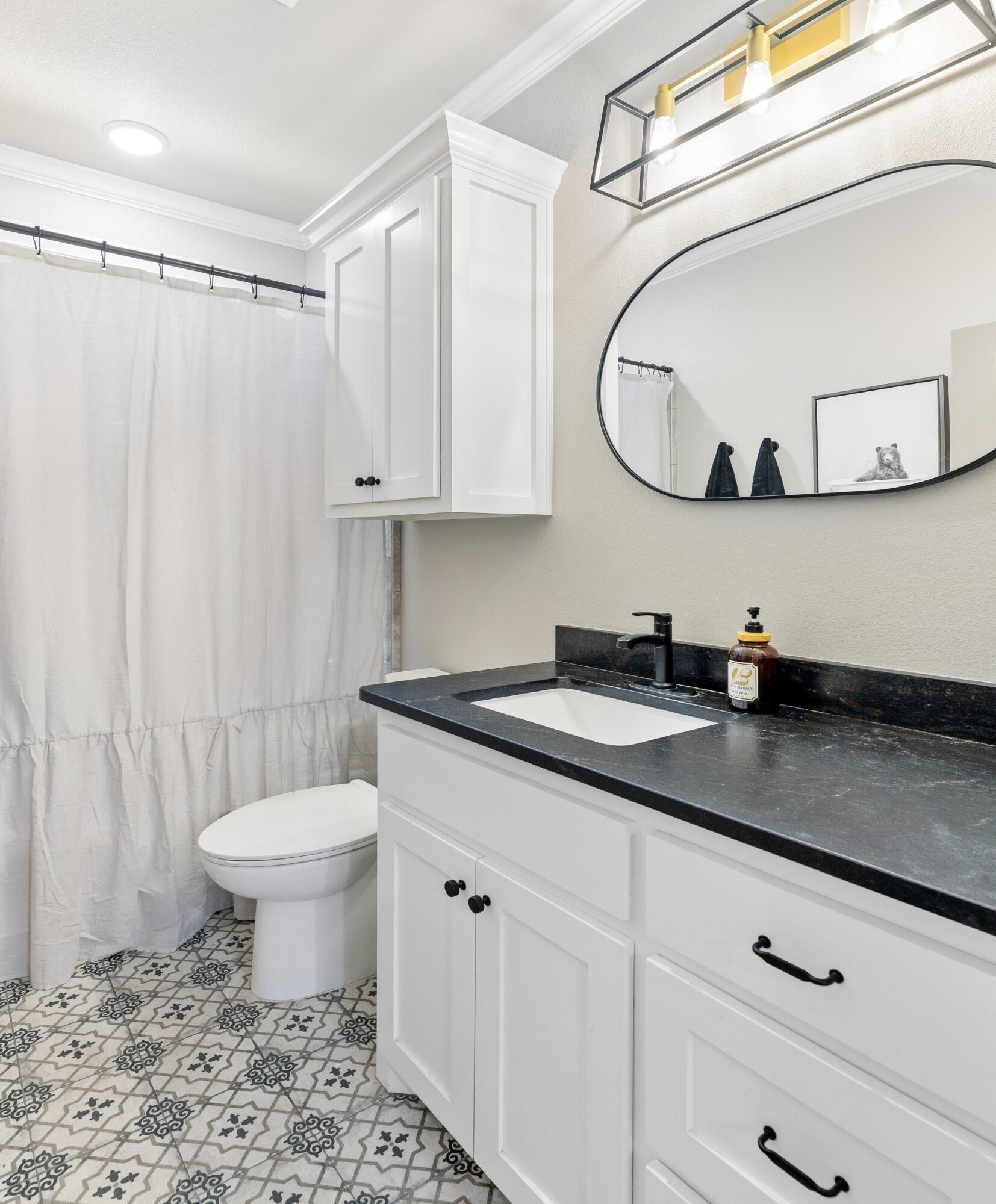 629 North 9th Street Wolfforth, TX 79382 - Photo 32 of 45 a bathroom with a granite countertop sink a toilet and a mirror
