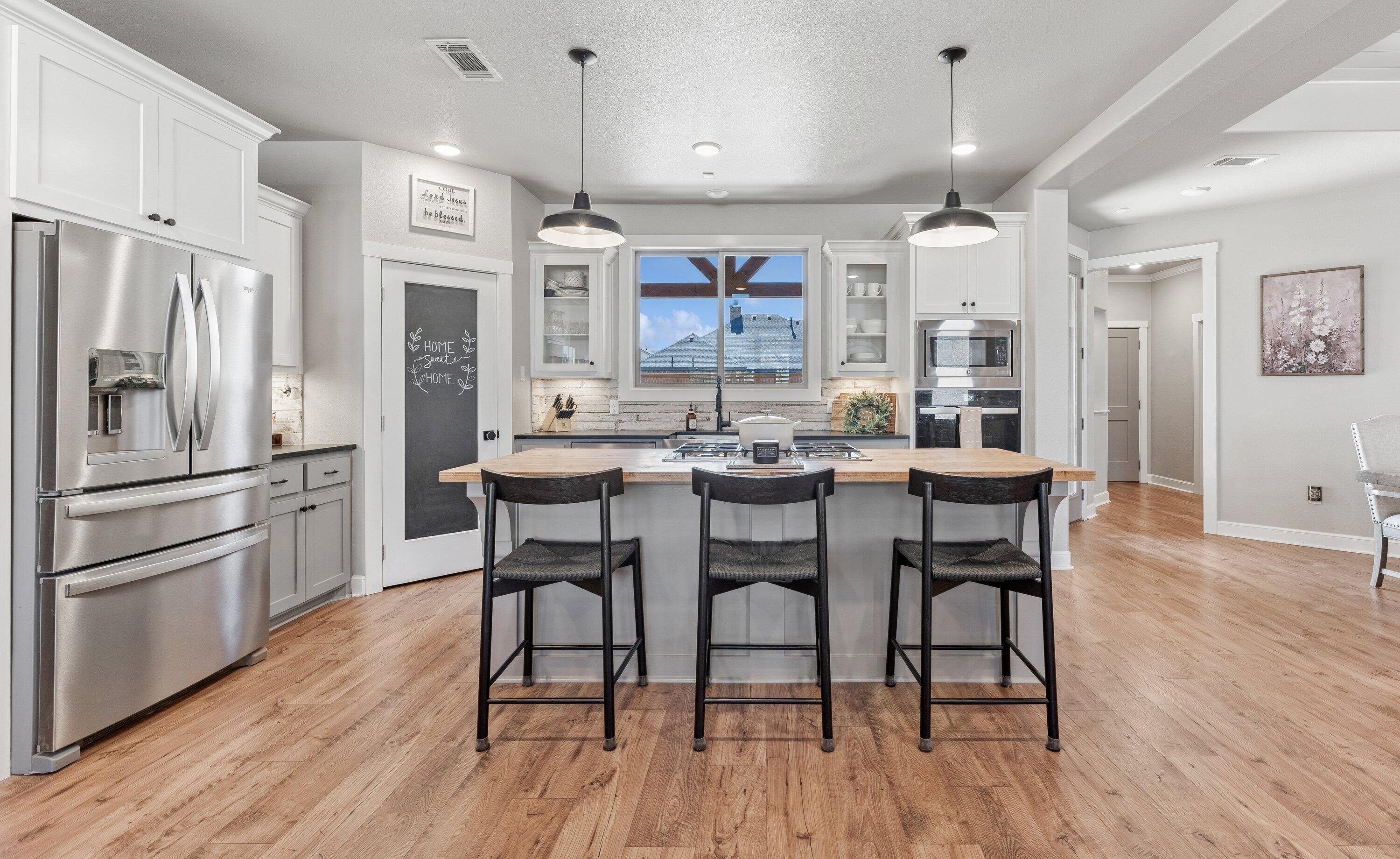 629 North 9th Street Wolfforth, TX 79382 - Photo 10 of 45 a kitchen with stainless steel appliances a dining table chairs refrigerator and sink