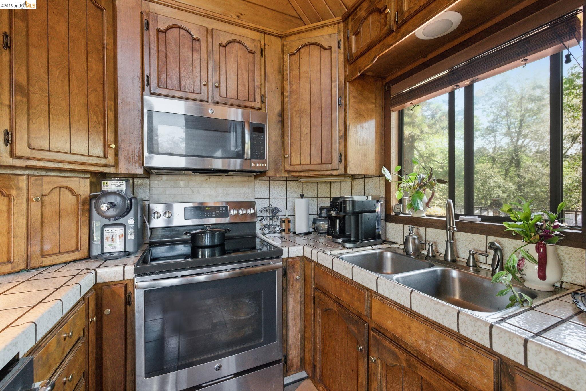 22555 South Fork Road Sonora, CA 95370 - Photo 7 of 35 a kitchen with stainless steel appliances granite countertop a sink a stove and a microwave