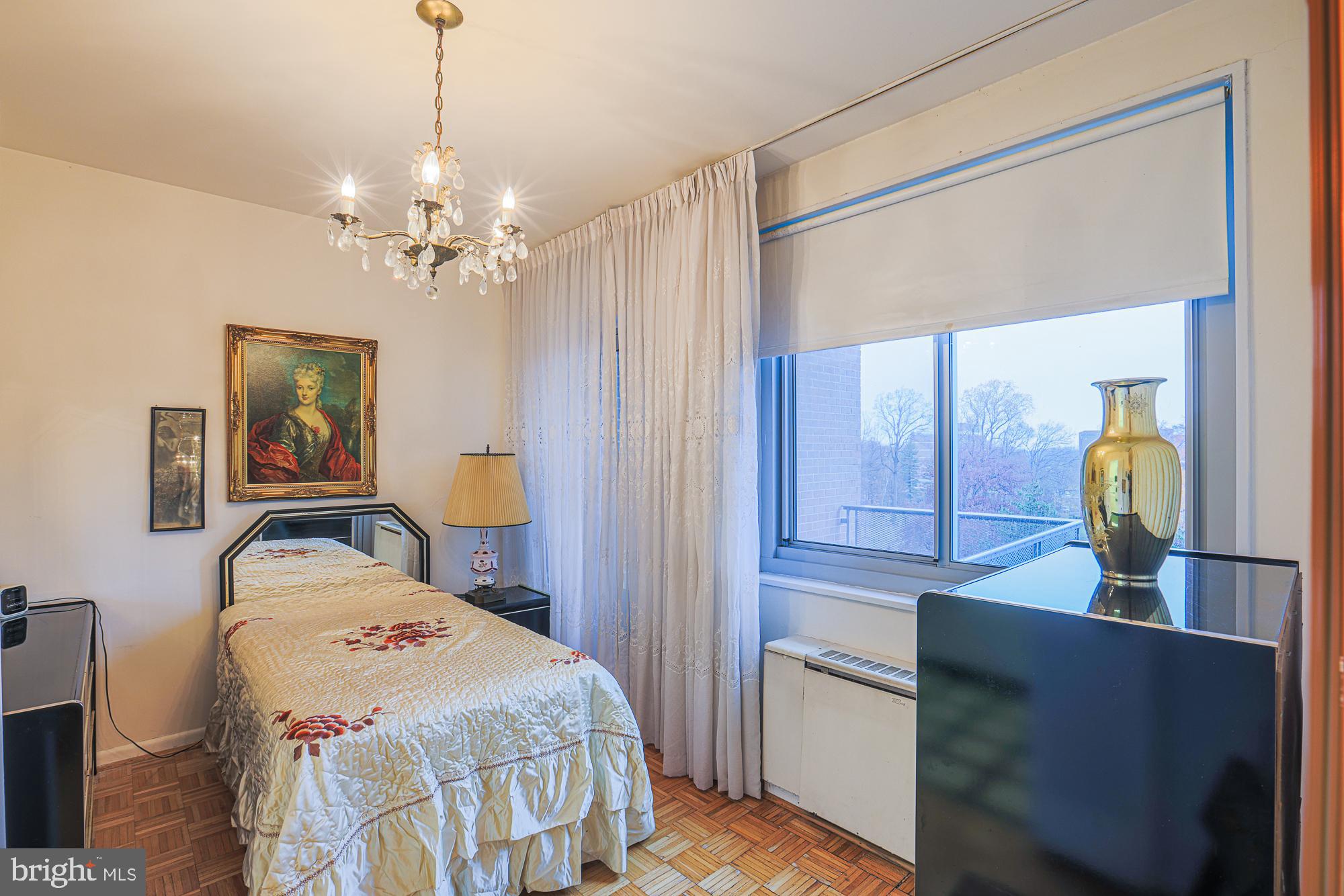 11 Slade, Unit 614 Pikesville, MD 21208 - Photo 15 of 38 a bedroom with a bed and a chandelier