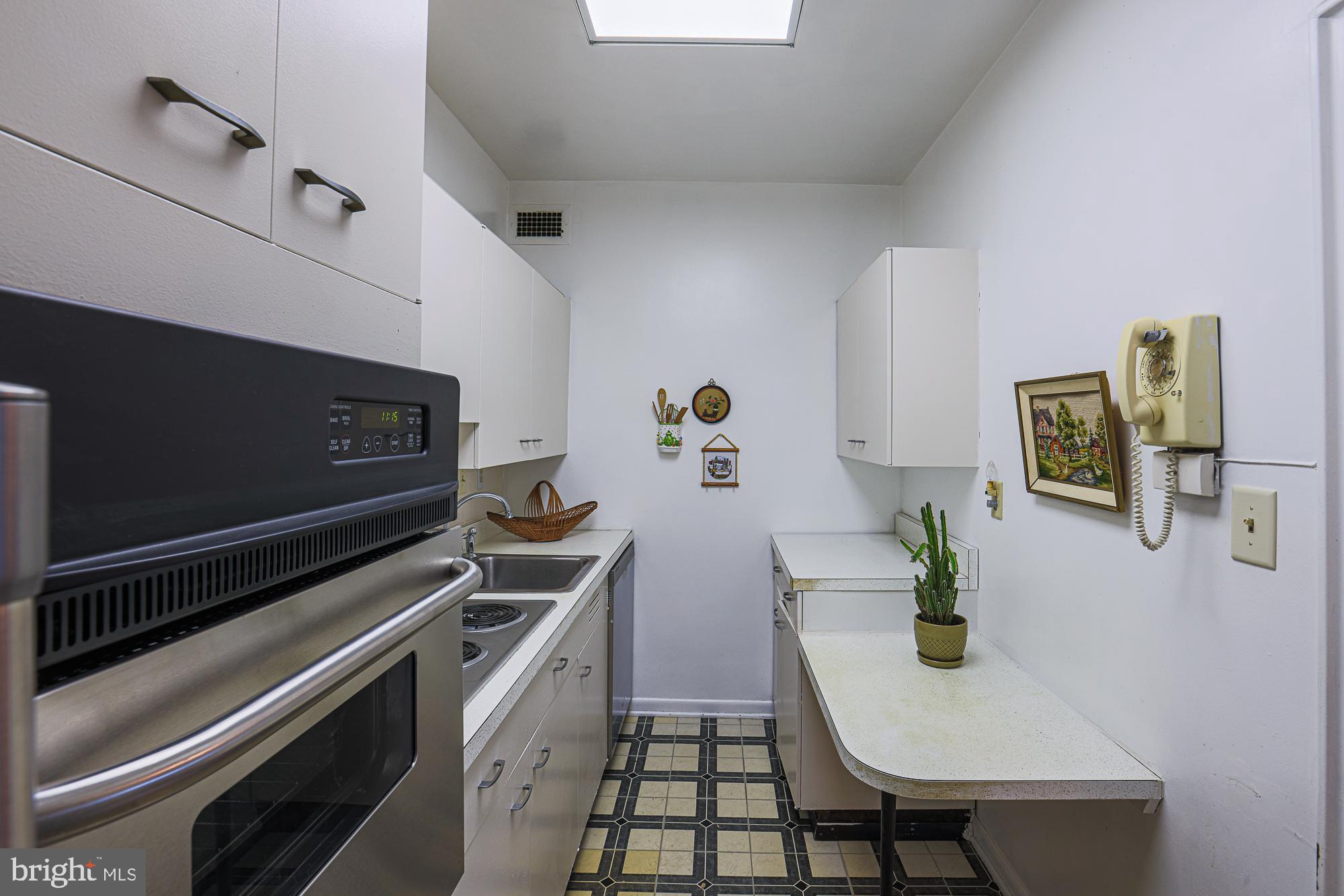 11 Slade, Unit 614 Pikesville, MD 21208 - Photo 18 of 38 a kitchen with stainless steel appliances a stove a sink cabinets and a dining table