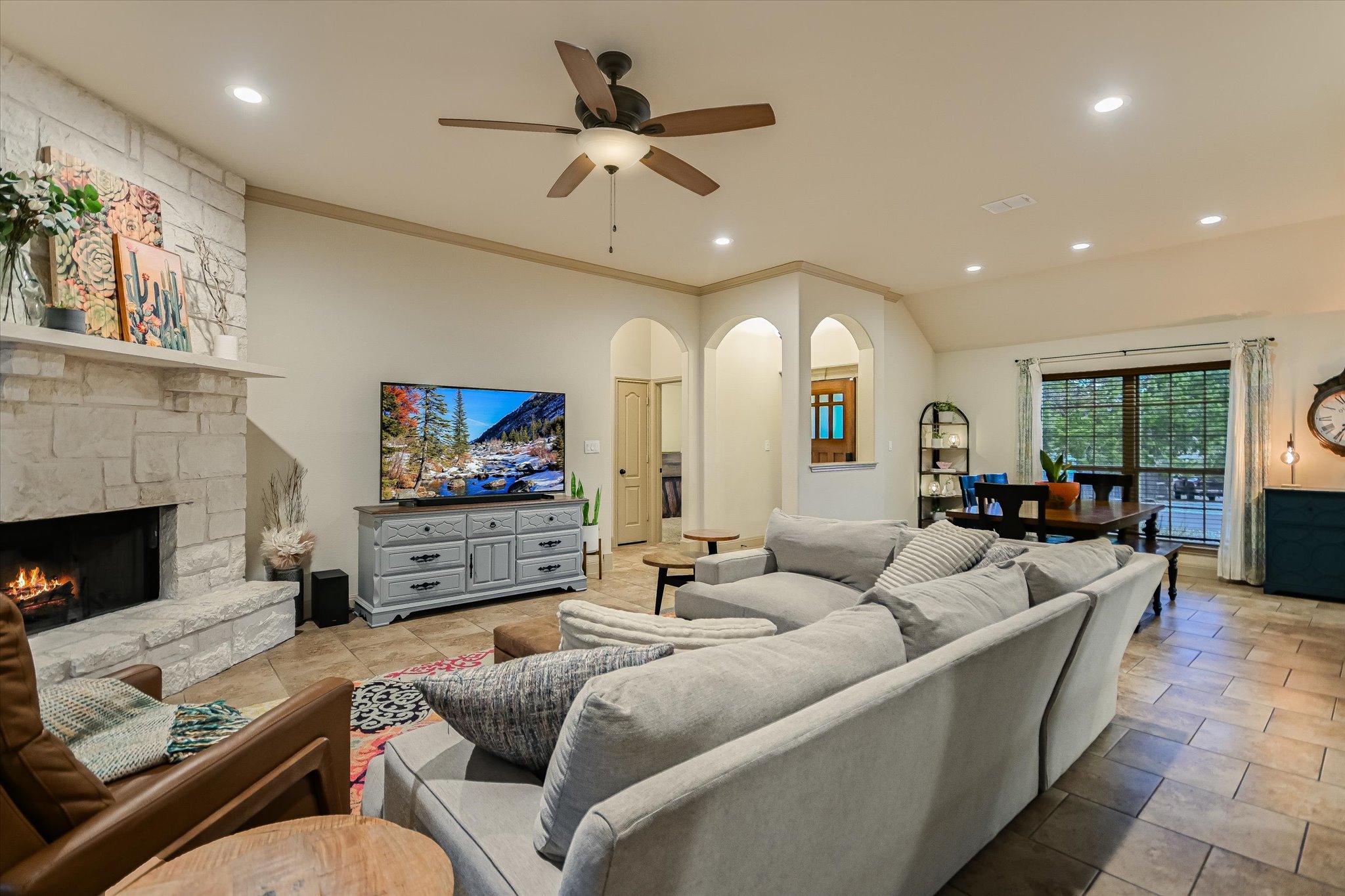36 Ridgewood Circle Wimberley, TX 78676 - Photo 8 of 30 Stone masonry fireplace and neutral tile flooring anchor this airy open living area.