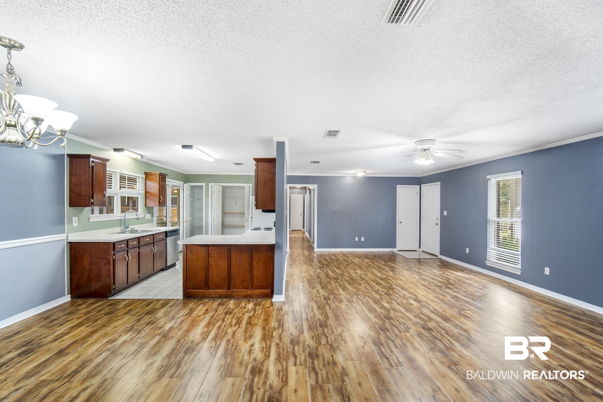 103 Ann Street Daphne, AL 36527 - Photo 22 of 23 Kitchen with ornamental molding, open floor plan, light countertops, a peninsula, and light wood-style flooring