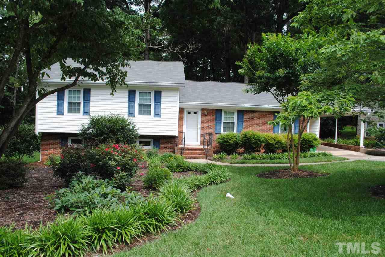 a front view of a house with a yard and potted plants