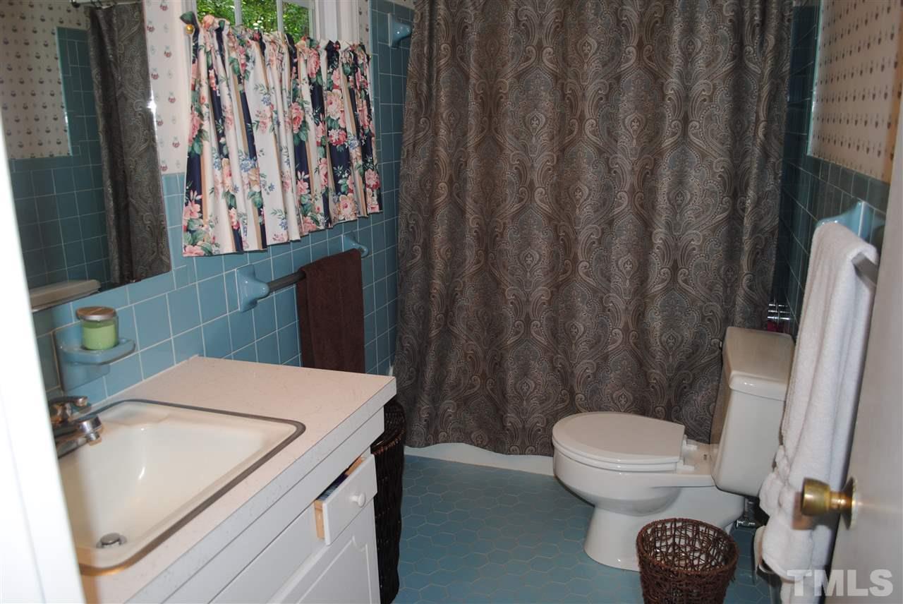 5508 Knollwood Road Raleigh, NC 27609 - Photo 16 of 19 a bathroom with a sink a toilet and a shower curtain