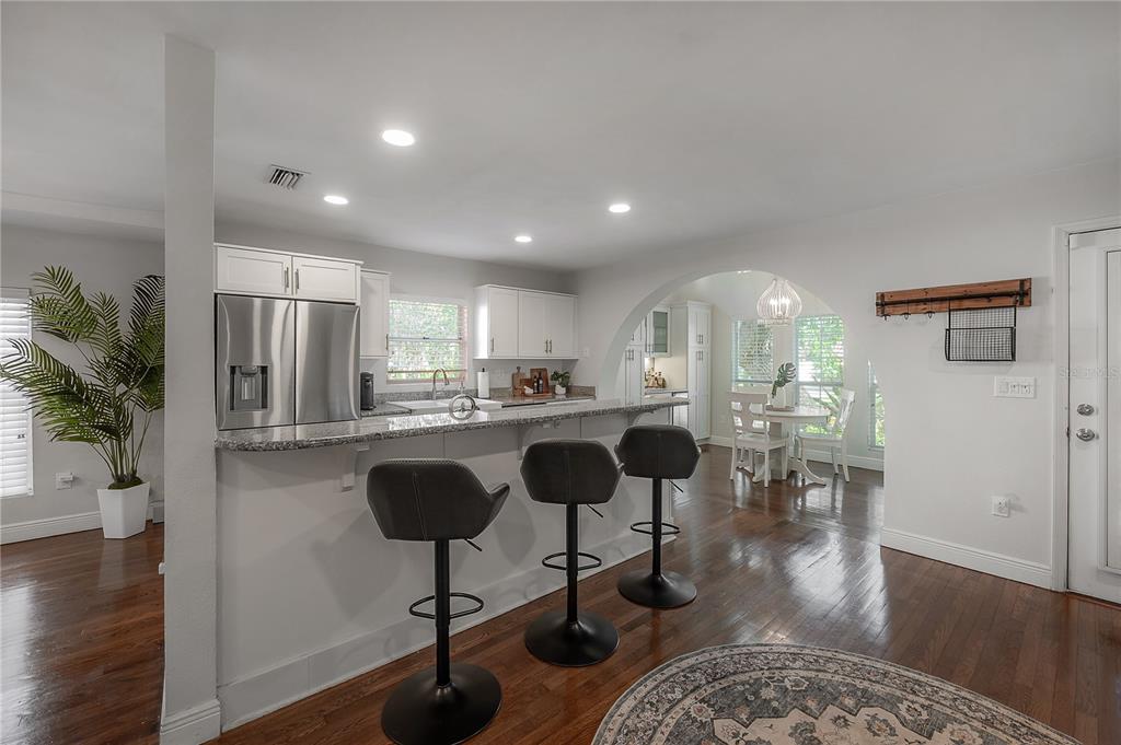 3108 West Villa Rosa Street Tampa, FL 33611 - Photo 13 of 58 a kitchen with stainless steel appliances granite countertop a refrigerator a stove a dining table and chairs with wooden floor