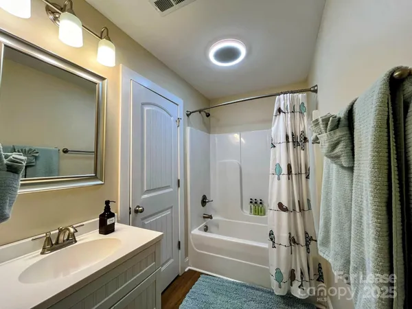 a bathroom with a tub sink and mirror