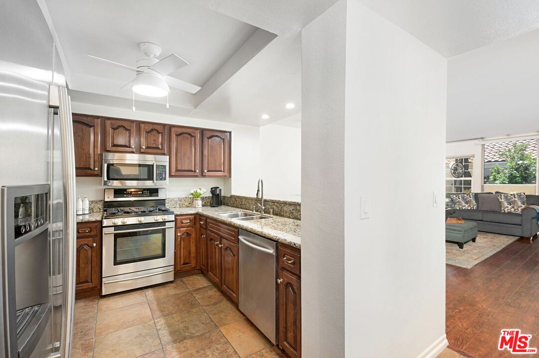 4240 Lost Hills Road, Unit 2602 Calabasas, CA 91301 - Photo 12 of 38 a kitchen with stainless steel appliances granite countertop a stove and a refrigerator