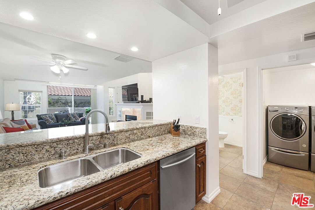 4240 Lost Hills Road, Unit 2602 Calabasas, CA 91301 - Photo 14 of 38 a kitchen with a sink and a stove top oven with wooden floor