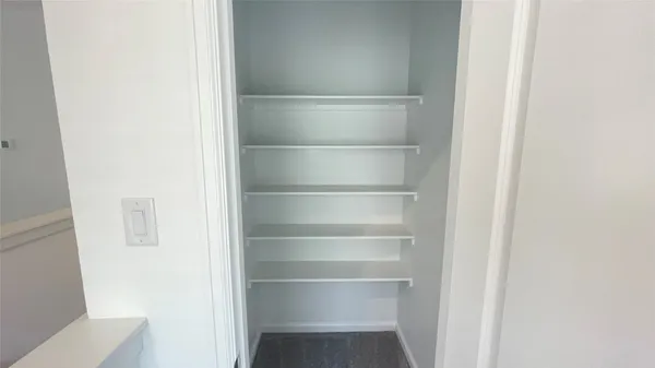 a view of a walk in closet with empty racks