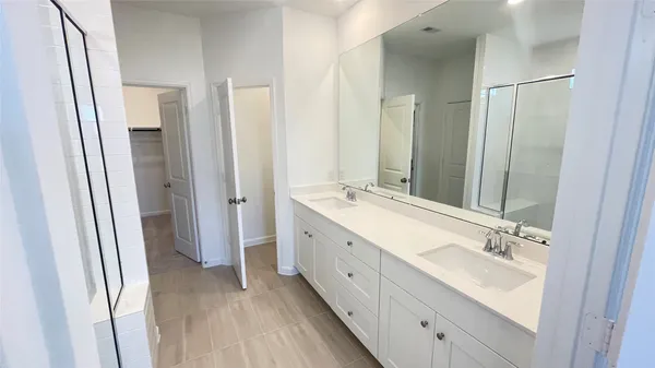 a spacious bathroom with a double vanity sink and a mirror