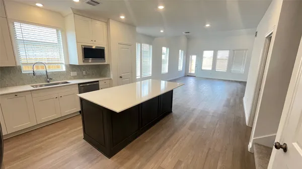 a kitchen with a sink window and cabinets
