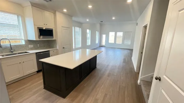 a kitchen with a sink refrigerator and microwave