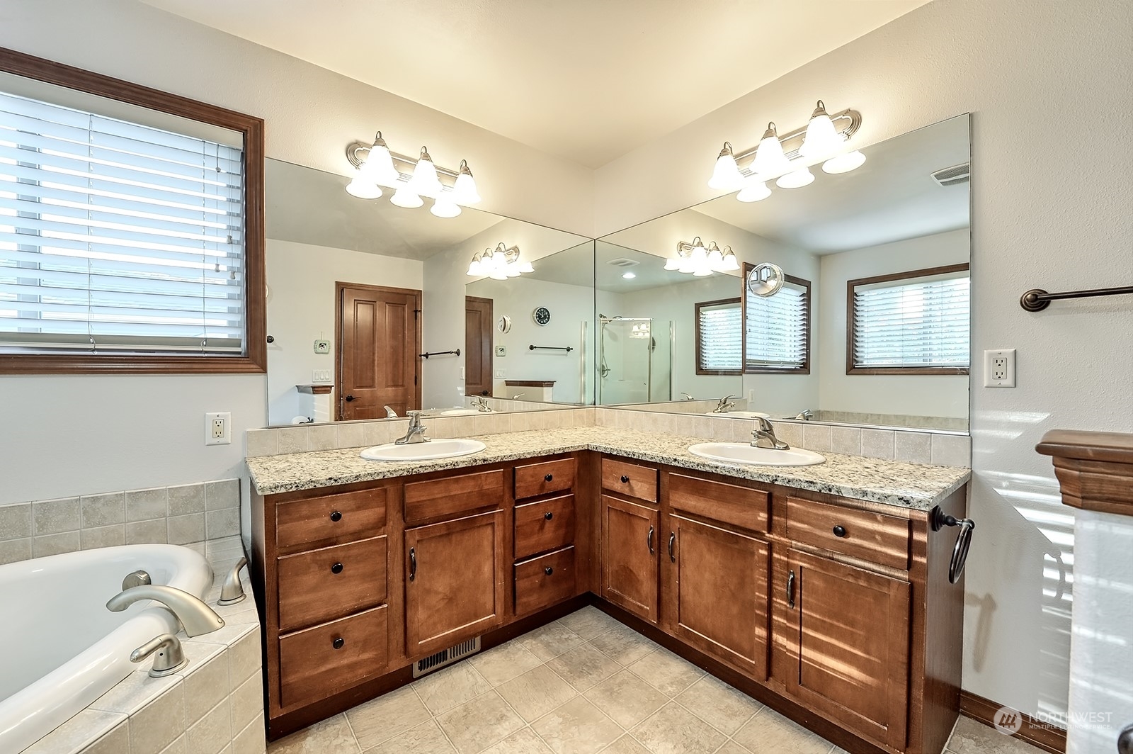 5576 Old Settler Drive Ferndale, WA 98248 - Photo 16 of 20 a spacious bathroom with a granite countertop sink a large mirror and a bathtub