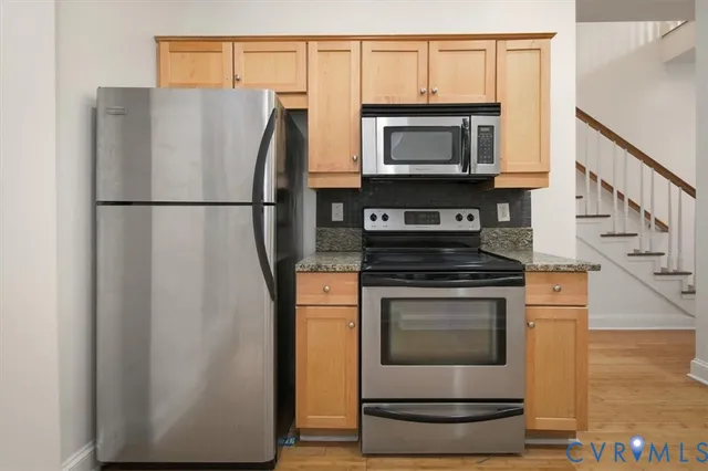 a white refrigerator freezer and a stove sitting inside of a kitchen