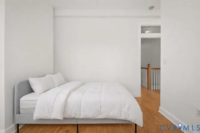 a bedroom with a bed and wooden floor