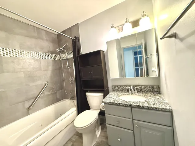 a bathroom with a sink and mirror with bathtub