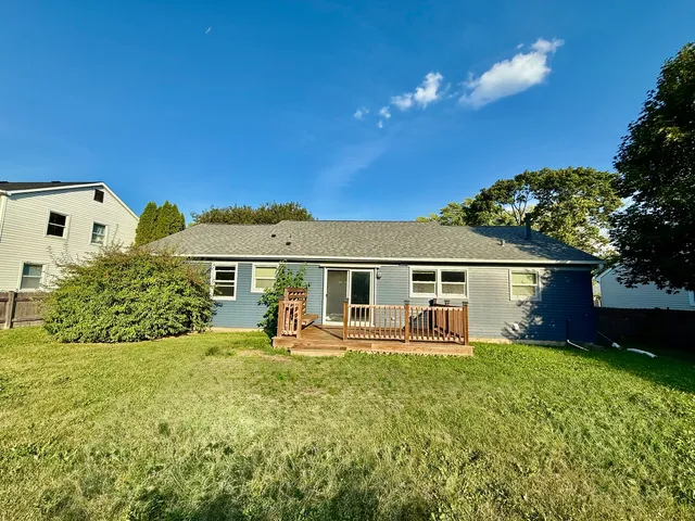 a front view of house with yard and trees in the background