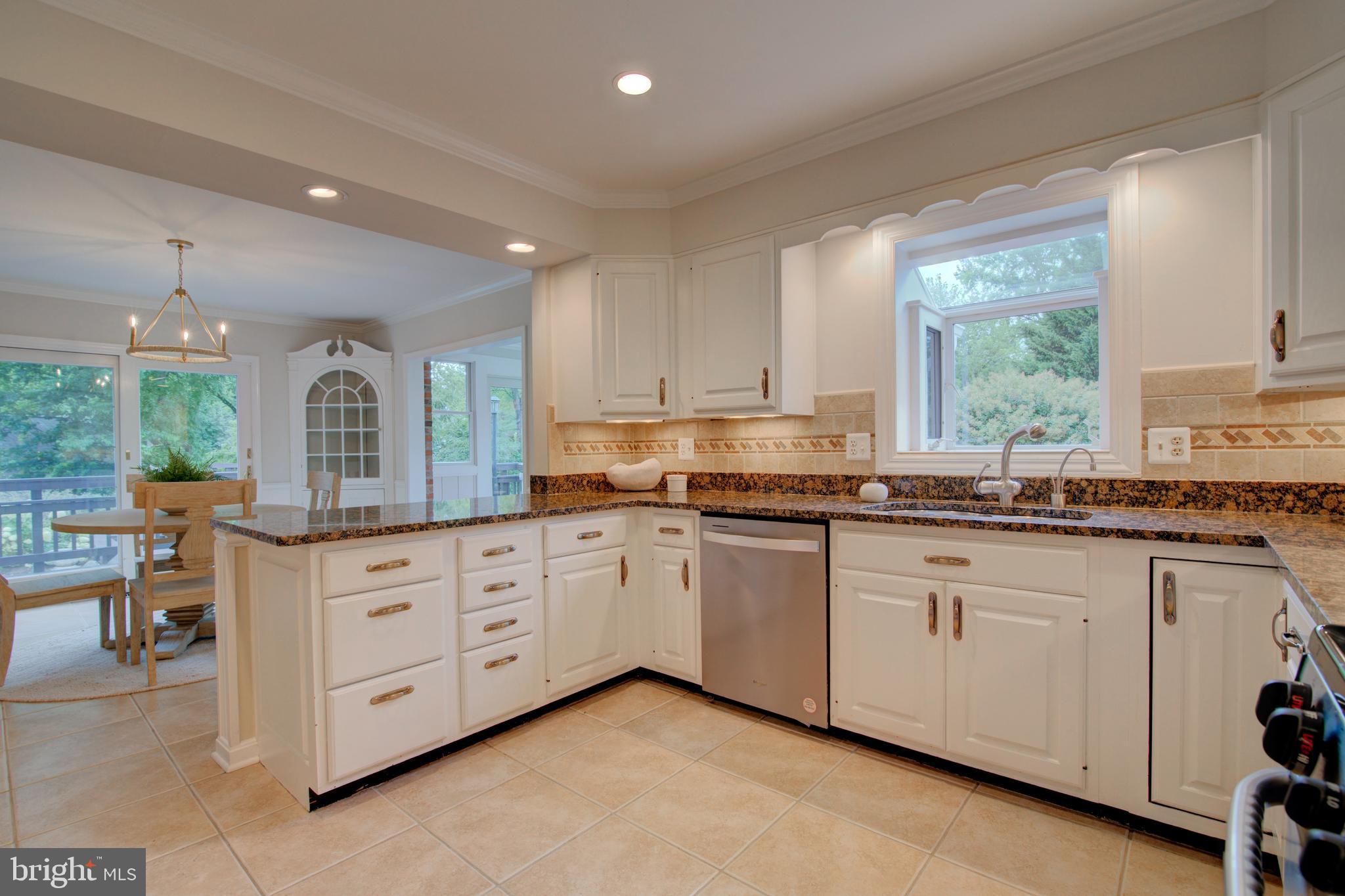 10405 Trumpeter Court Vienna, VA 22182 - Photo 16 of 43 a open kitchen with granite countertop a stove sink and cabinets