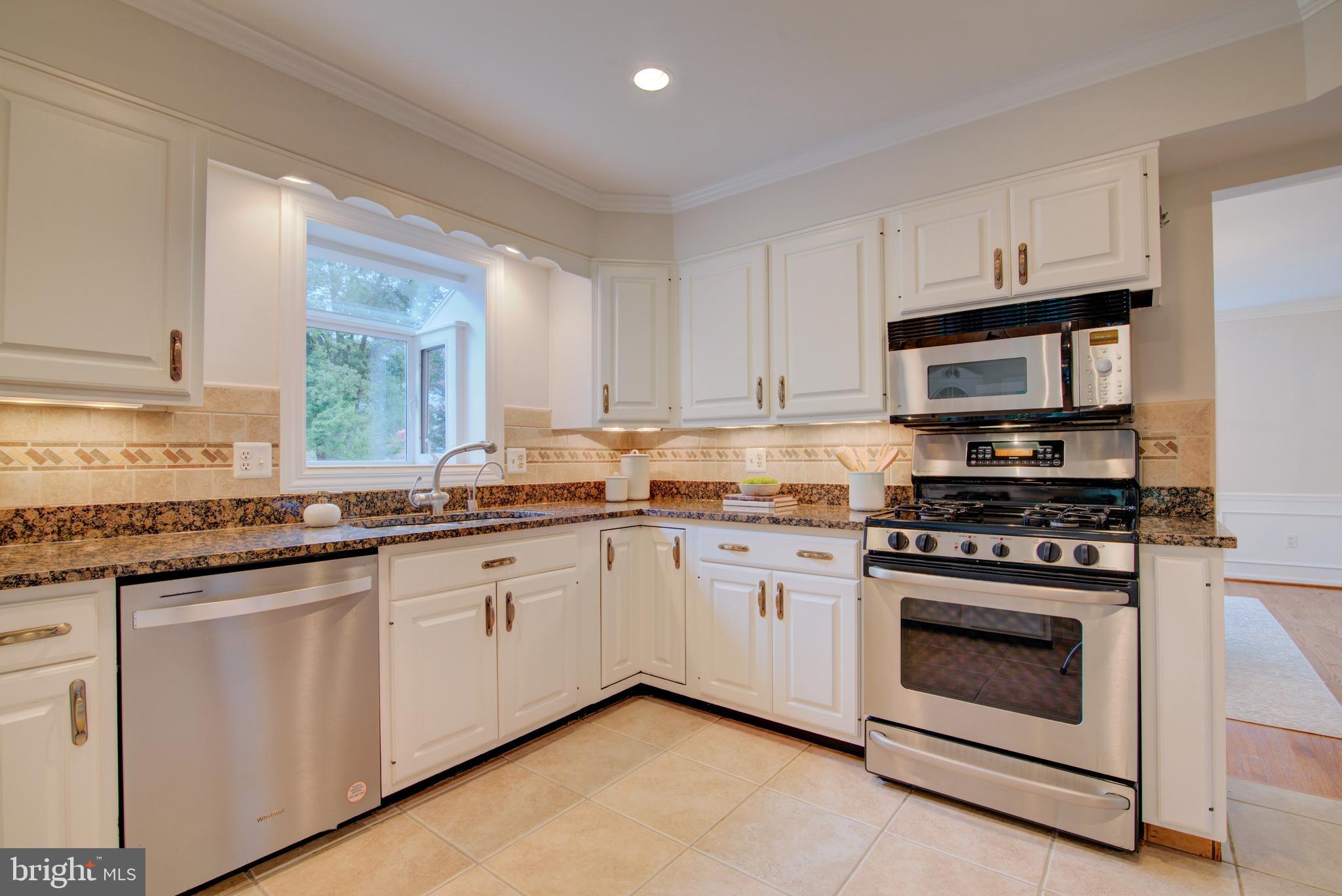 10405 Trumpeter Court Vienna, VA 22182 - Photo 17 of 43 a kitchen with stainless steel appliances granite countertop a stove a sink and a microwave